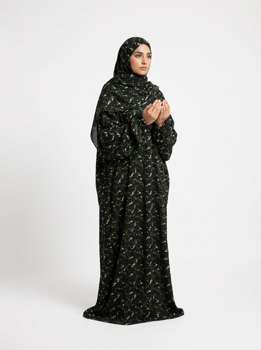 Black Floral Prayer Abaya front view, model in prayer pose, integrated hijab. #colour_black